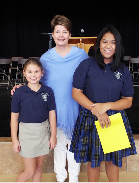 Fifth-grader Kate Brink, left, and eighth-grader Bianca Dapon, right finished first and second respectively in their school's spelling bee Nov. 6 at St. Francis Xavier. They are pictured with their principal, Kim Cavnar. (courtesy photo)