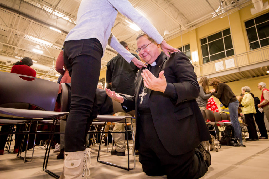 A John 17 Movement participant prays over Auxiliary Bishop Eduardo A. Nevares Nov. 2 at the Salvation Army KROC Center in South Phoenix. More than 150 Catholics and Christians from other denominations joined in prayer, praise and worship at the ecumenical event. (Billy Hardiman/CATHOLIC SUN)