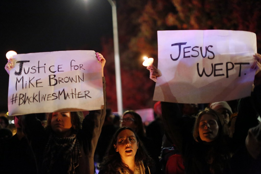 Demonstrators hold signs during a Nov. 24 Oakland, Calif., demonstration following the decision by a Missouri grand jury not to indict a white Ferguson police officer in the Aug. 9 fatal shooting of unarmed black teenager Michael Brown in the St. Louis suburb. (CNS photo/Stephen Lam, Reuters)