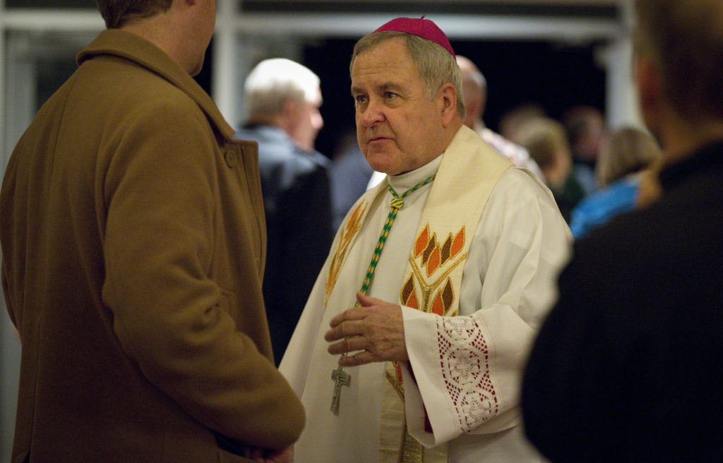 St. Louis Archbishop Robert J. Carlson greets parishioners of Blessed Teresa of Calcutta Church in Ferguson, Mo., Nov. 24 following a prayer service. The service was held as violence began to erupt in the town following the announcement that a St. Louis County grand jury determined there was not enough evidence to indict Ferguson, Mo., Police Officer Darren Wilson in the Aug. 9 shooting death of Michael Brown. (CNS photo/Lisa Johnston, St. Louis Review)