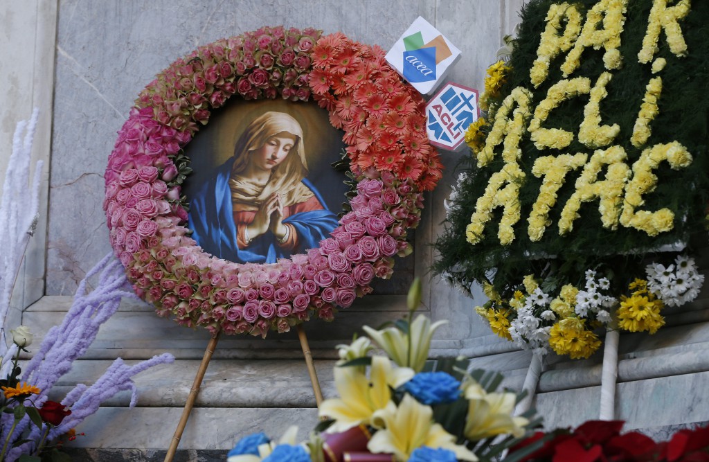 An image of Mary is adorned with flowers at the foot of a tall Marian statue overlooking the Spanish Steps in Rome Dec. 8, the feast of the Immaculate Conception. Rome's firefighters have observed the tradition every year since 1857. (CNS photo/Paul Haring)