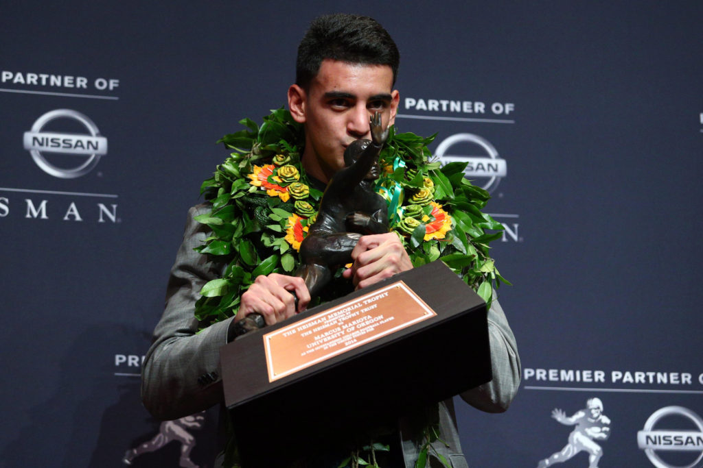 Oregon Ducks quarterback Marcus Mariota kisses the Heisman Trophy during a Dec. 13 news conference at the New York Marriott Marquis after he was named the recipient of the trophy. Mariota is not Catholic but he regularly attends team Masses and graduated from an all-boys Catholic high school in Honolulu. (CNS photo/Brad Penner, USA Today Sports via Reuters)