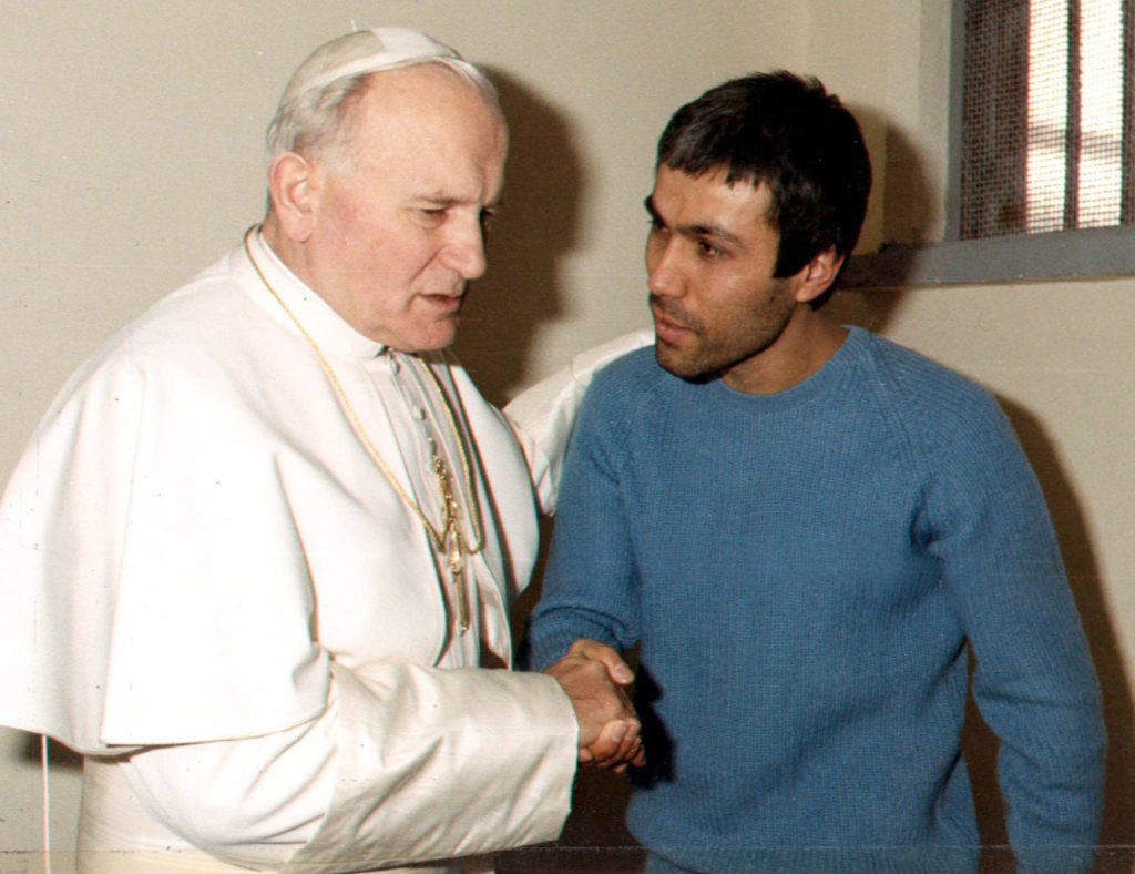Pope John Paul II shakes hands with his would-be assassin, Mehmet Ali Agca, in a Rome prison Dec. 27, 1983. Exactly 31 years after St. John Paul II personally forgave him for shooting and trying to assassinate him, Agca returned to the Vatican with a bunch of white roses and laid them at the late pope's tomb. (CNS photo/L'Osservatore Romano via EPA)  