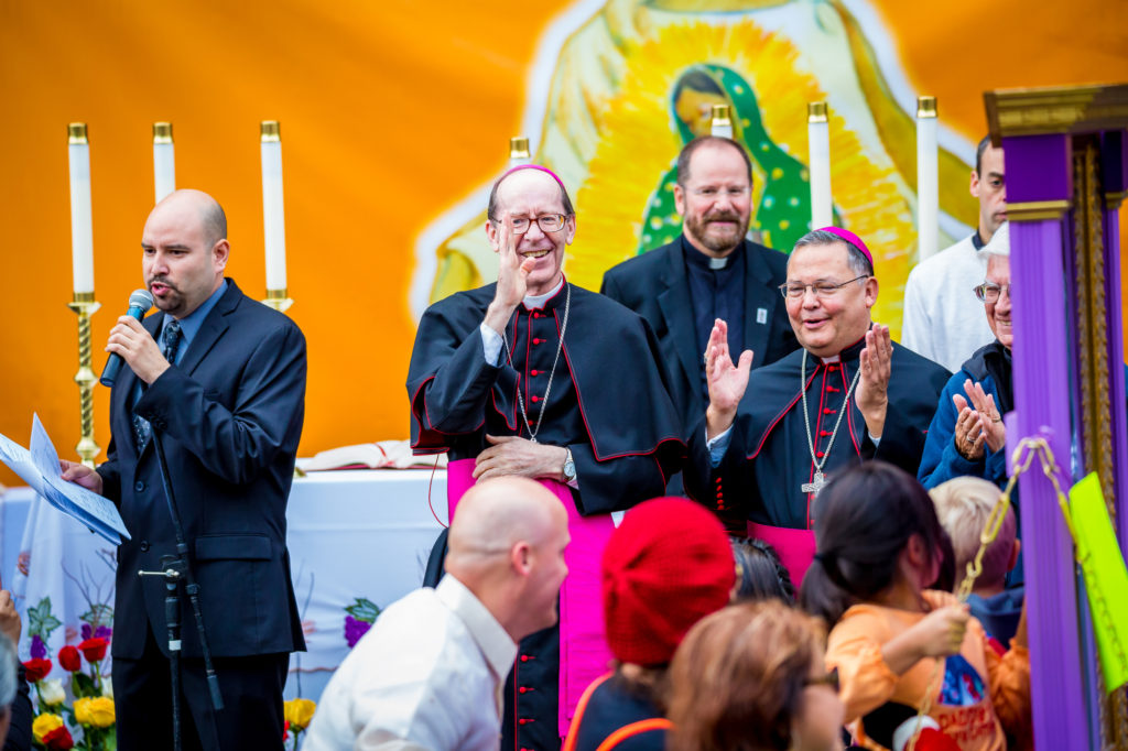 Bishop Thomas J. Olmsted and Auxiliary Bishop Eduardo A. Nevares look on as thousands of people process through the streets of downtown Phoenix Dec. 6 in our outpouring of love for Our Lady of Guadalupe at the annual Honor Your Mother event. (Billy Hardiman/CATHOLIC SUN)