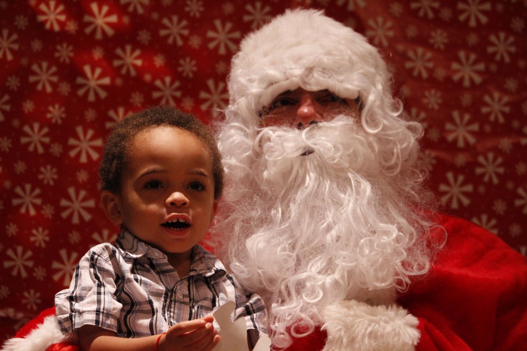 A 2-year-old boy poses for a quick picture with Santa during a Dec. 6 Christmas party hosted at St. Thomas More Parish in Glendale. He was able to leave the foster care system as his adoption was finalized in September. 