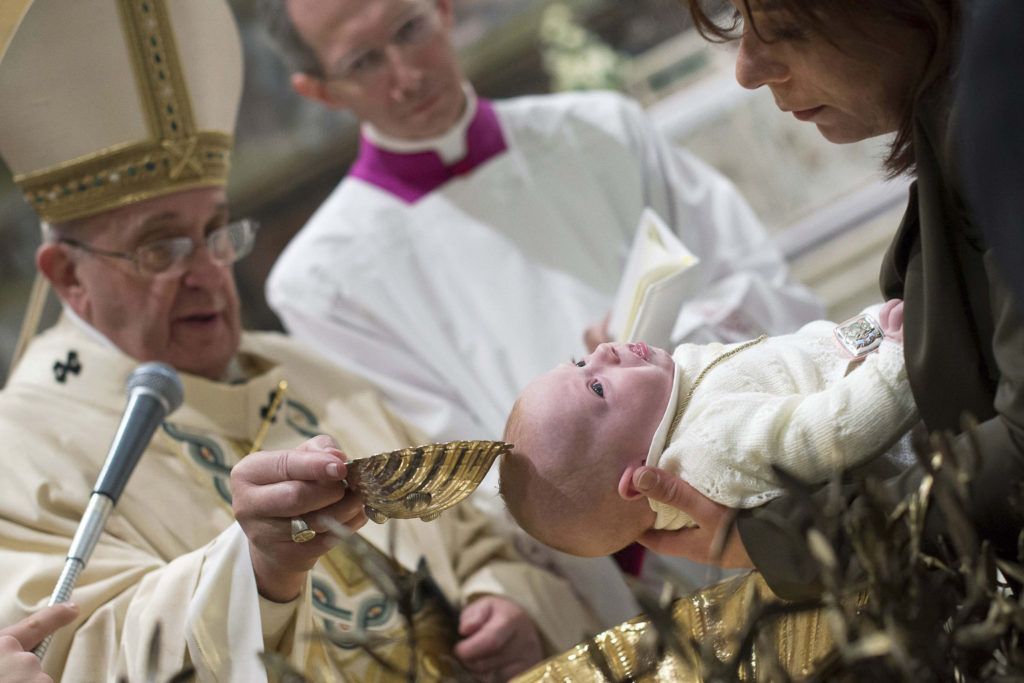 Pope Francis baptizes a newborn during a Mass in the Sistine Chapel at the Vatican Jan. 11. Pope Francis baptized 33 infants during the Mass and told the mothers to feel free to breast-feed them if they cried or were hungry. (CNS photo/L'Osservatore Romano via Reuters)