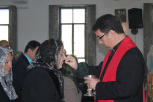 Bishop Oscar Cantu of Las Cruces, N.M., distributes Communion to displaced Iraqi Christians during a Jan. 20 visit to northern Kurdistan. Bishop Cantu traveled to northern Iraq with a delegation from the U.S. Conference of Catholic Bishops Jan. 16-20 to see the needs of displaced Christians and other religious minorities. (CNS photo/Dale Gavlak) 