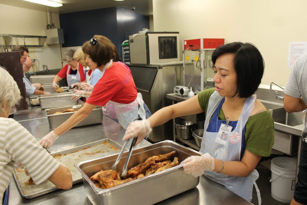 Volunteers from Our Lady of Perpetual Help Parish, Scottsdale, prepared lunch for guests at the St. Vincent de Paul Dining Room in Phoenix July 4, 2014. Some 1.2 million meals are served to the hungry each year at five local dining rooms. Serving others is one way to find joy. (Joyce Coronel/CATHOLIC SUN)