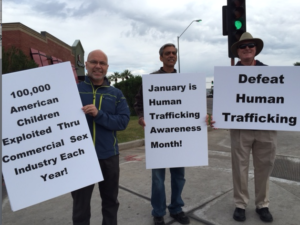 Fr. Ray Ritari, pastor at St. Matthew Parish in Phoenix, Ariz., joined Chris Fleischman and Michael Bradley, members of the parish social justice group, at a busy street corner Jan. 10 to draw awareness to the evils of human sex trafficking. January is designated as "human trafficking awareness month." A second collection taken at Masses Jan. 11 netted more than $1,000 to support the work of a halfway house in San Diego run by Sisters of the Divine Savior. They assist women who have escaped from human trafficking. (courtesy photo)