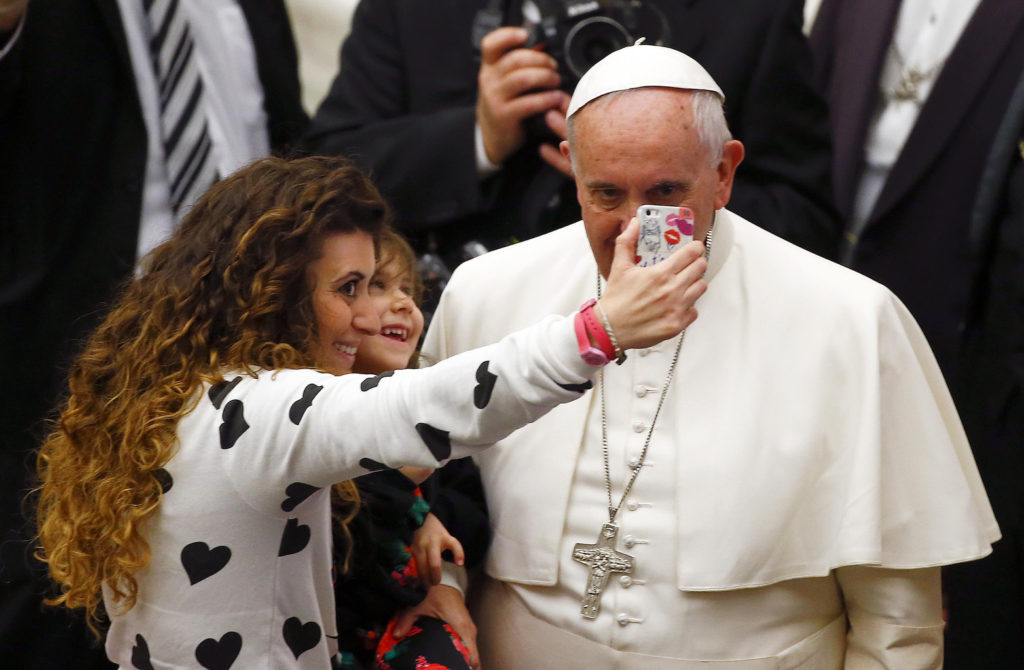 A woman holding her daughter takes a selfie with Pope Francis during his weekly audience in Paul VI hall at the Vatican Jan.21. (CNS photo/Tony Gentile, Reuters) 