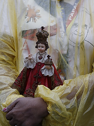 A woman holds a statue of statue of Santo Nino, the Holy Child Jesus, as Pope Francis celebrates Mass at Rizal Park in Manila, Philippines, Jan. 18. The Mass was celebrated on the feast of Santo Nino and texts at the Mass were those of the Philippines for the feast day. (CNS photo/Paul Haring)