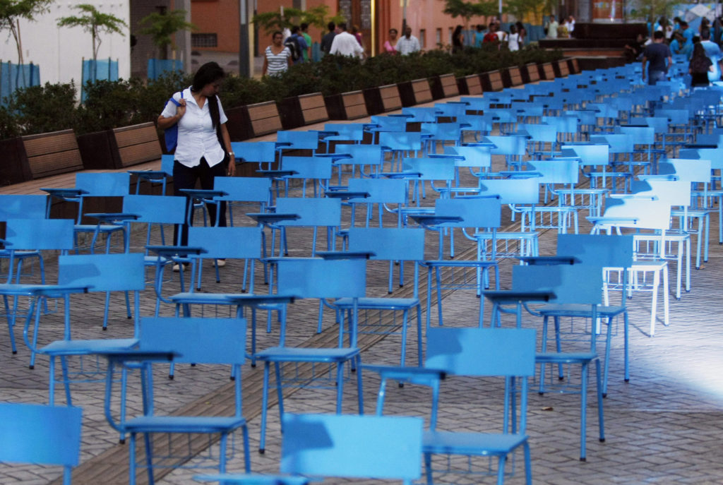 A girl walks among a blue chairs installation for Human Trafficking Awareness Day in Cali, Colombia, July 30, 2014. The chair represent more than 20 million men, women and children who are victims of human trafficking worldwide. (CNS photo/Christian Escobar Mora, EPA) 