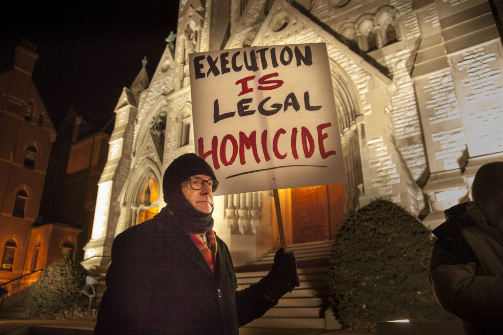 Christian Gohl holds a sign during a vigil held Jan. 28 outside St. Louis University College Church ahead of the execution of death-row inmate Herbert Smulls of St. Louis. Smulls, 56, was executed after midnight Jan. 29 at the penitentiary in Bonne Terre, Mo. Convicted in a 1991 murder committed during a jewelry store robbery, Smulls was granted a temporary stay of execution by the U.S. Supreme Court Jan. 28 but his appeals ran out and he was put to death by lethal injection. (CNS photo/Lisa Johnston, St. Louis Review)  