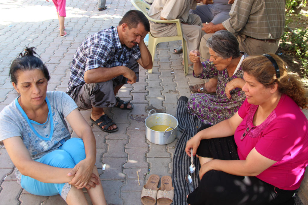 People displaced by violence sit outside St. Joseph Chaldean Catholic Church in Ankawa, Iraq, Aug. 14.  A typical day for many Iraqi Christians encamped at Ankawa, near Irbil, would probably involve another round of struggle against desperation, frustration, anxiety, boredom and fear. (CNS photo/courtesyvAid to the Church in Need-USA)  