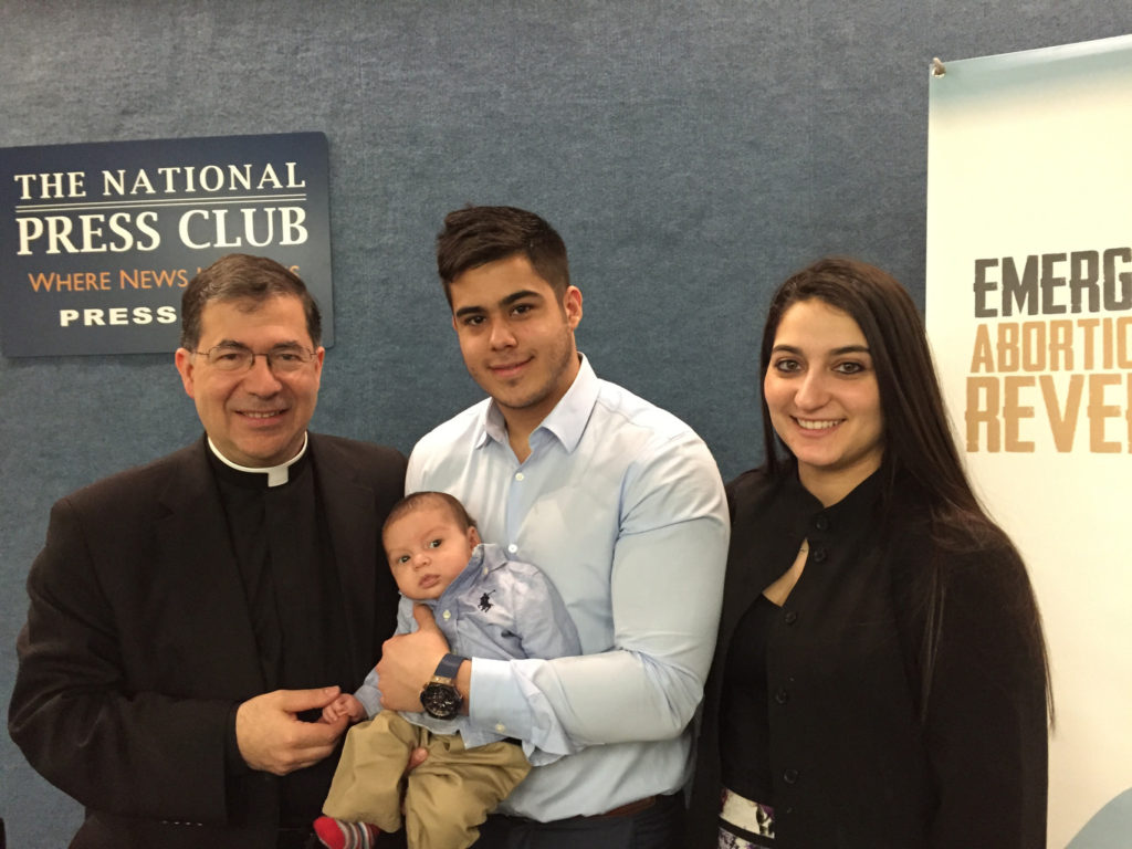 Fr. Frank Pavone, national director of Priests for Life, poses with Chris Caicedo, Andrea Minichini and their son, Gabriel Caicedo, following a news conference at the National Press Club in Washington Feb. 23 to call attention to a protocol to reverse RU-486 medical abortions. (CNS photo/Priests for Life) 