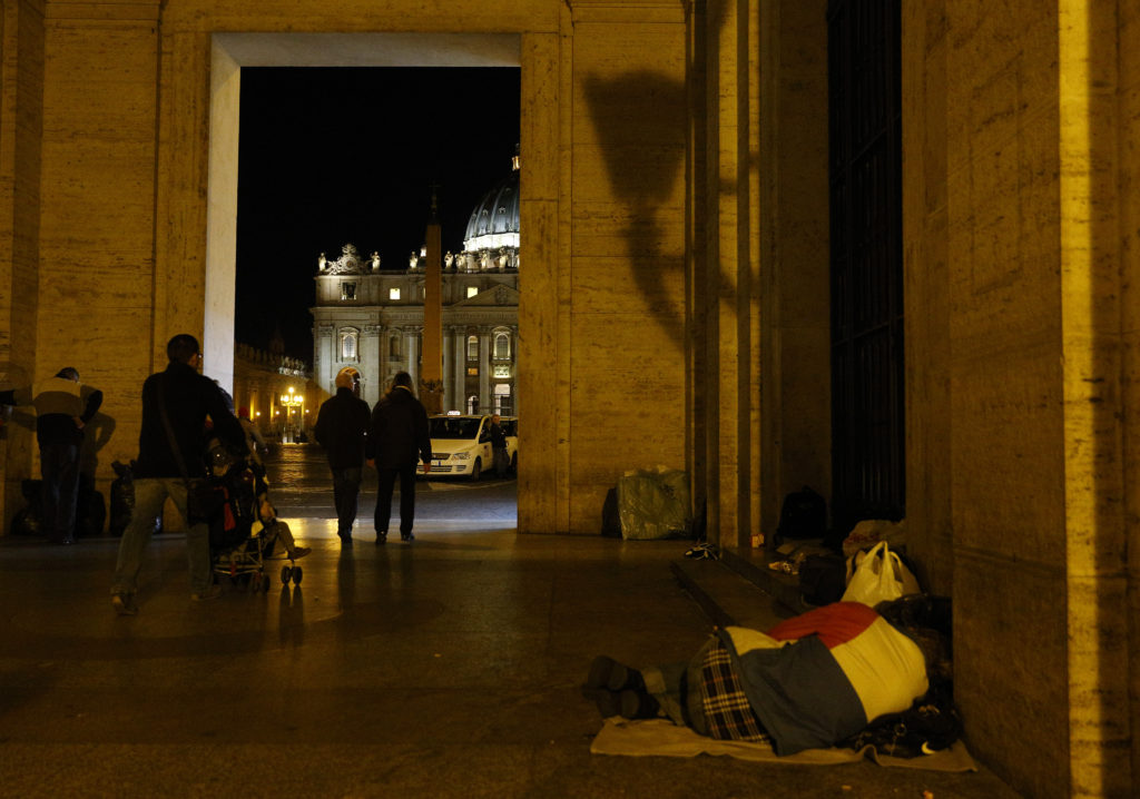 A homeless person sleeps outside the Vatican press office near St. Peter's Square Nov. 13. Public restrooms in St. Peter's Square will be renovated to include showers so the homeless can wash. Dozens of homeless people live within sight of the Vatican. (CNS photo/Paul Haring) 