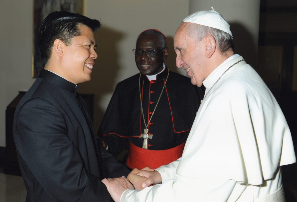 Msgr. Peter Bui, pictured here with Pope Francis and Cardinal Robert Sarah in May 2014, serves at the Vatican as an official with Cor Unum, the pope’s humanitarian arm. His family came to the U.S. in the 1970s alongside thousands of “boat people” who escaped the religious persecution of Vietnam. (courtesy photo)