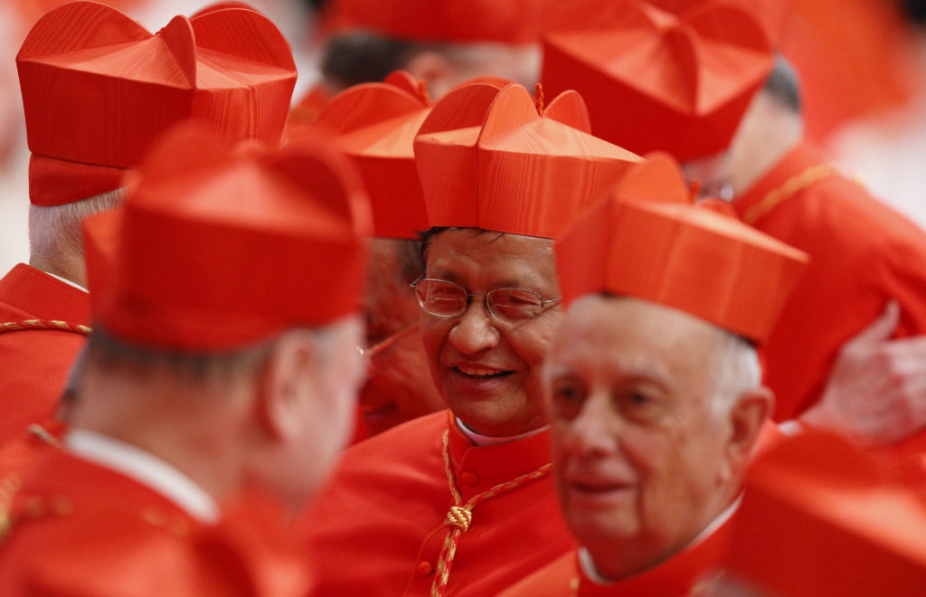 New Cardinal Charles Bo of Yangon, Myanmar, center, greets other cardinals after receiving his red biretta from Pope Francis during a consistory at which the pope created 20 new cardinals in St. Peter's Basilica at the Vatican Feb. 14. (CNS photo/Paul Haring)