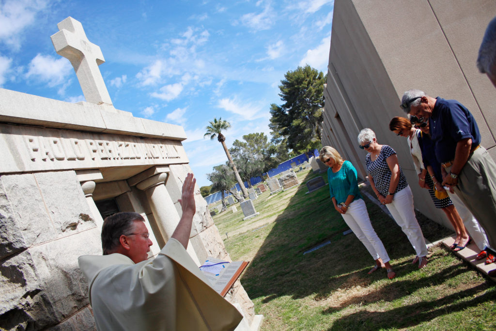 Officials at St. Francis Cemetery and Mortuary in Phoenix cleaned up and fixed the Paolo Perazzo Vault that contains the bodies of seven extended family members. Fr. Chuck Kieffer, at left, blessed the family vault Feb. 19 in a private ceremony with five descendants in attendance. (Ambria Hammel/CATHOLIC SUN)
