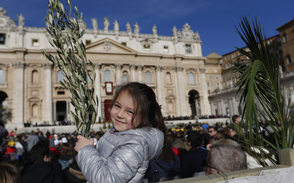 A girl holds palms before the start of Palm Sunday Mass celebrated by Pope Francis in St. Peter's Square at the Vatican March 29. (CNS photo/Paul Haring)