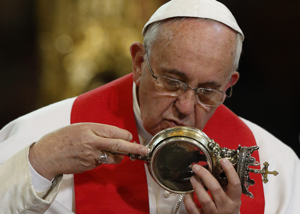 Pope Francis kisses a reliquary containing what is believed to be the blood of St. Januarius during a meeting with religious at the cathedral in Naples, Italy, March 21. The dried blood of the saint is said to liquefy several times a year. After the pope handled the relic, the blood apparently liquefied. (CNS photo/Paul Haring) 
