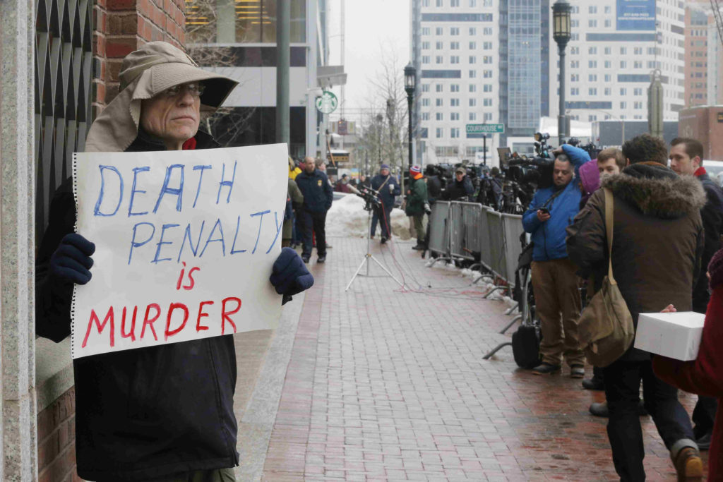 A man holds a sign reading "Death penalty is murder" March 4 outside the trial of accused Boston Marathon bomber Dzhokhar Tsarnaev in Boston. Four nationally circulated Catholic publications called for abolishing the death penalty in the United States in a jointly published editorial March 5. (CNS photo/Brian Snyder, Reuters) 