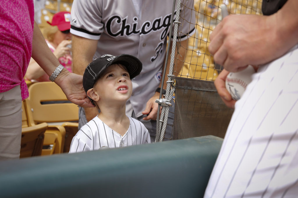 A young fan looks up to Tyler Flowers of the Chicago White Sox as the catcher signs baseballs during spring training March 11 at Camelback Ranch ballpark in Glendale, Arizona. (CNS photo/Nancy Wiechec) 