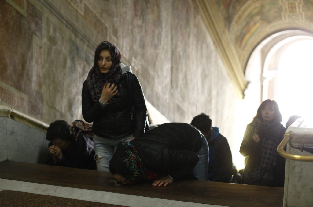 People pray on the Holy Stairs at the Pontifical Sanctuary of the Holy Stairs in Rome March 10. Tradition maintains that Jesus climbed the stairs when Pilate brought him before the crowd. It's believed that Constantine's mother, St. Helen, brought the stairs to Rome from Jerusalem in 326. (CNS photo/Paul Haring) 