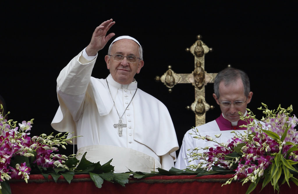 Pope Francis greets the crowd after delivering his Easter message and blessing "urbi et orbi" (to the city and the world) from the central balcony of St. Peter's Basilica at the Vatican April 5. (CNS photo/Paul Haring)