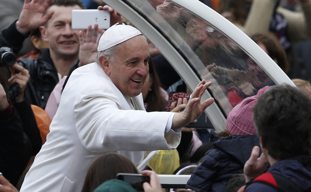 Pope Francis reaches to greet child after celebrating Easter Mass in St. Peter's Square at Vatican