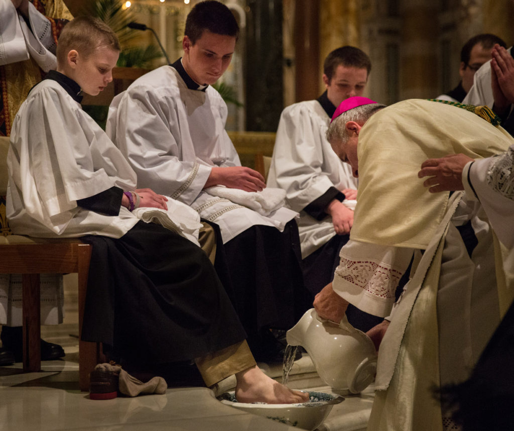 St. Louis Archbishop Robert J. Carlson washes the feet of Brett Haubrich, a sixth-grader at St. Mark School in Affton, Mo., who was diagnosed with a brain tumor last summer, during Mass on Holy Thursday, April 2, at the Cathedral Basilica of St. Louis. At the invitation of Archbishop Carlson, Brett took his place beside the altar at the cathedral as "Priest for a Day." (CNS photo/Lisa Johnston, St. Louis Review)