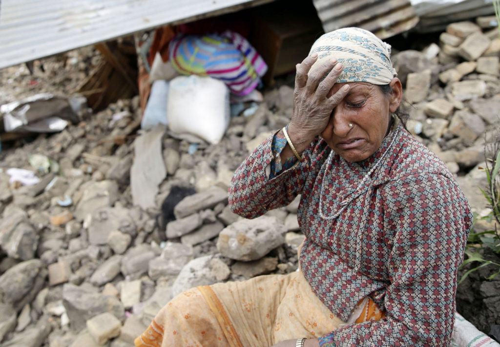 A woman mourns near the body of her 10-year-old daughter outside her destroyed home April 27 on the outskirts of Kathmandu, Nepal. More than 4,300 people were known to have been killed and an estimated 1 million people were left homeless after a magnitude-7.8 earthquake hit a mountainous region near Kathmandu April 25. (CNS photo/Narendra Shrestha, EPA) 
