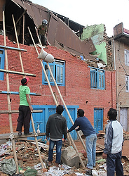 Earthquake survivors use a makeshift bamboo stand to help retrieve valuable possessions from a collapsed building at Lalitpur village on the outskirts of Kathmandu, Nepal, April 29. (CNS photo/Anto Akkara) 