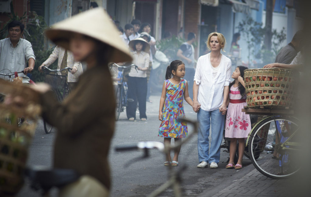 Deirdre O'Kane, with children, stars in a scene from the movie "Noble." The film, which will debut on 150 screens nationwide May 8, tells the story of an Irish woman with an indomitable spirit who years after raising her own children went to Vietnam to help orphans. (CNS photo/Aspiration Media)