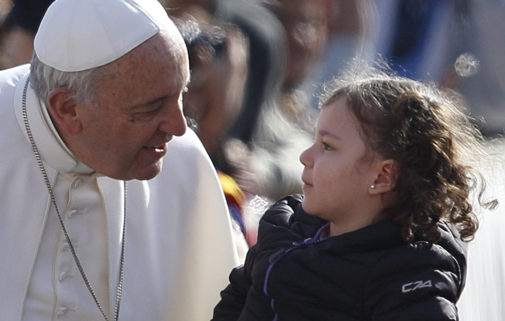 Pope Francis greets a child as he arrives for his general audience in St. Peter's Square at the Vatican April 1. (CNS photo/Paul Haring) 
