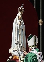 Pope Francis touches the original statue of Our Lady of Fatima at the start of a Mass in honor of Mary in St. Peter's Square at the Vatican in this Oct. 13, 2013, file photo. The pope is deeply devoted to Mary and often expresses his devotion by praying in front of Marian statues and then gently touching them. (CNS photo/Paul Haring)