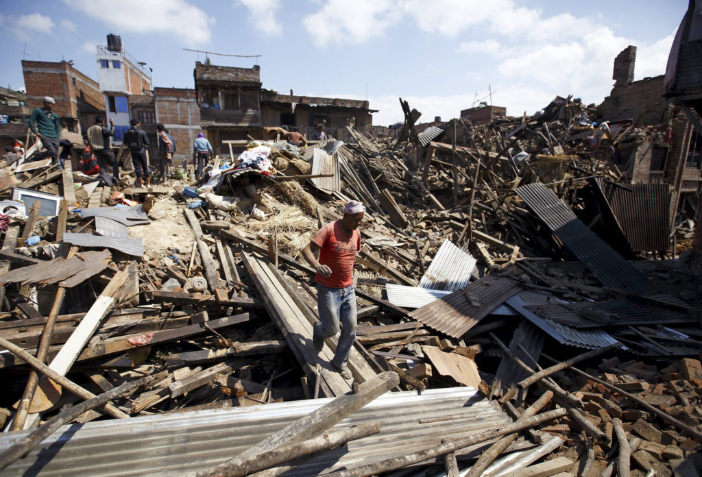 A man walks on the rubble of destroyed homes April 27 following an earthquake in Bhaktapur, Nepal. More than 3,600 people were known to have been killed and more than 6,500 others injured after a magnitude-7.8 earthquake hit a mountainous region near Kathmandu April 25. (CNS photo/Navesh Chitraka, Reuters) 