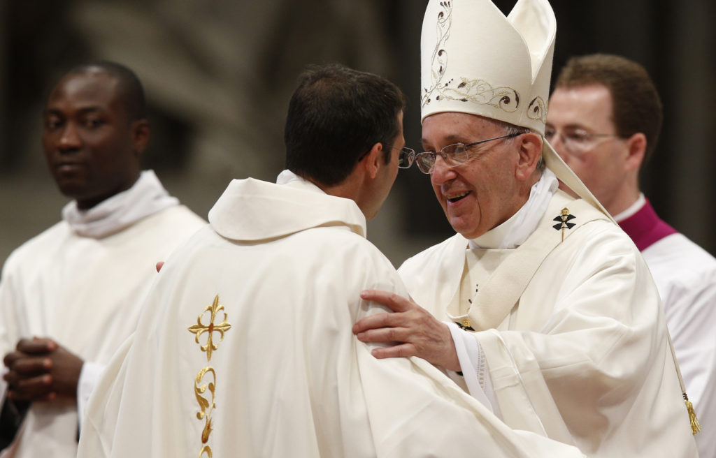 Pope Francis greets one of 19 new priests during an ordination Mass in St. Peter's Basilica at the Vatican April 26. In his homily, the pope told the new priests to make sure their homilies were not boring. (CNS photo/Paul Haring)