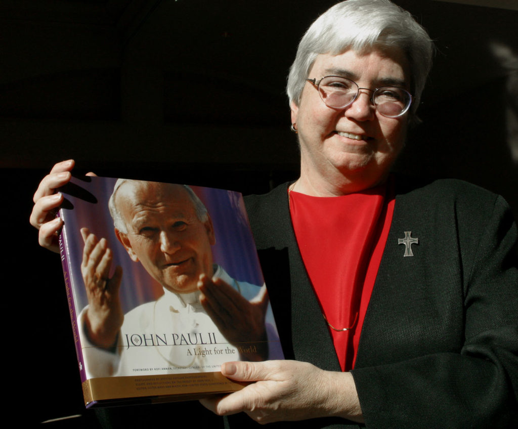 Mercy Sister Mary Ann Walsh is pictured in this 2003 photo holding a book she edited. The book is titled "John Paul II: A Light for the World." (CNS photo by Bob Roller) 