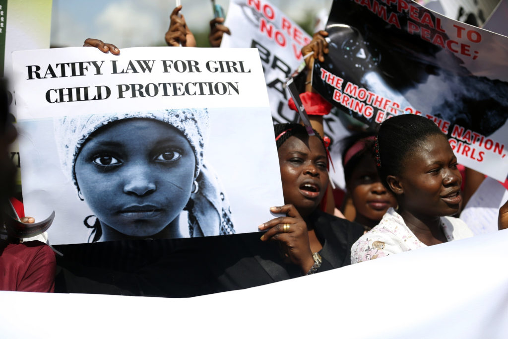 Women holding signs take part in a May 5 protest in Lagos, Nigeria, to demand the release of abducted high school girls. The Islamist militant group Boko Haram claimed responsibility for the abduction of 276 schoolgirls during a raid in the remote village of Chibok in April. (CNS photo/Akintunde Akinleye, Reuters)