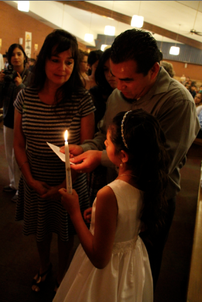 Godparents pray with their godchild immediately following their bapatism April 17 at Our Lady of Perpetual Help in Glendale. (Ambria Hammel/CATHOLIC SUN)