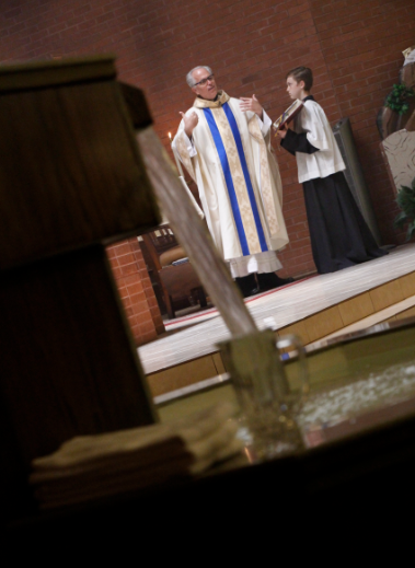 Fr. Mike Straley welcomes everyone to the special school liturgy April 17 when 20 were baptized into the faith. (Ambria Hammel/CATHOLIC SUN)