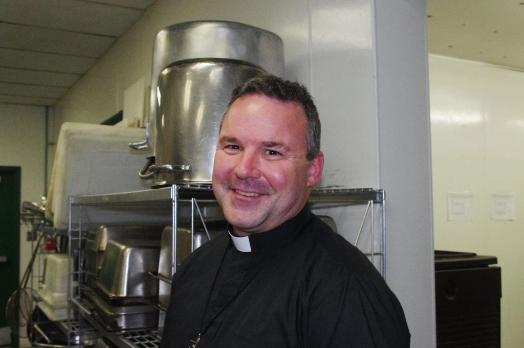 Holy Cross Father Thomas Doyle, director of André House, stands in the kitchen of the downtown outreach to the homeless and poor that has been feeding both bodies and souls for 30 years. (Joyce Coronel/CATHOLIC SUN)