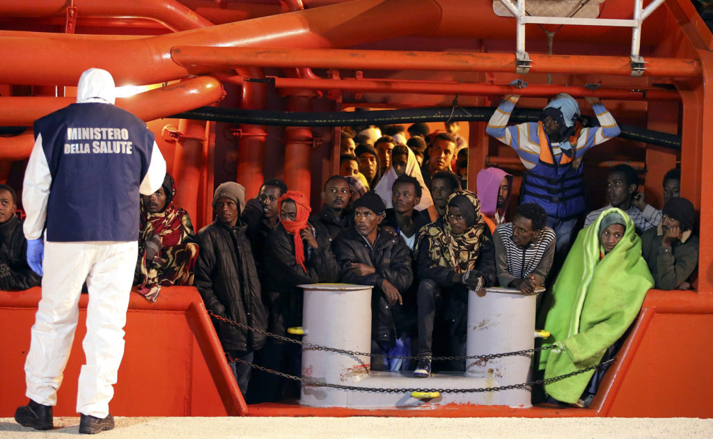 Migrants wait to disembark from a tug boat in the Sicilian harbor of Pozzallo May 4. More than 3,600 migrants were rescued at sea in 17 different operations in just one day in early May, according to the Italian coast guard. (CNS photo/Antonio Parrinello, Reuters) 