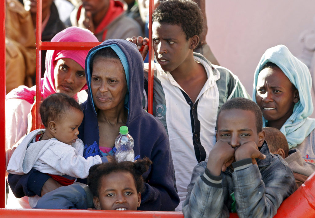 Migrants wait to disembark from a tug boat in the Sicilian harbor of Pozzallo May 4. More than 3,600 migrants were rescued at sea in 17 different operations in just one day in early May, according to the Italian coast guard. (CNS photo/Antonio Parrinello, Reuters)