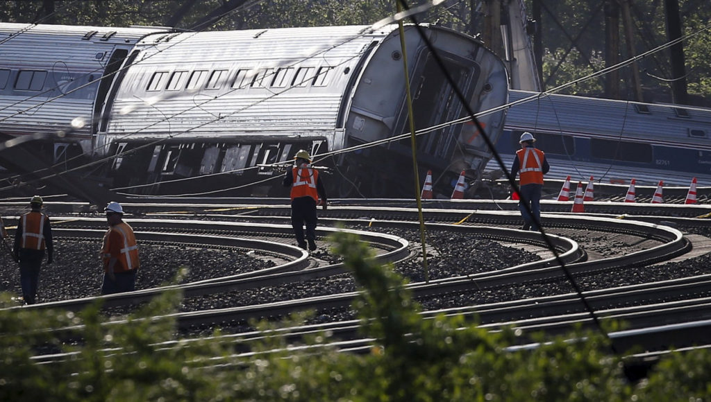Men walk toward the site of a derailed Amtrak train in Philadelphia May 13. Philadelphia Archbishop Charles J. Chaput urged prayers for all affected by the May 12 derailment in the city's Port Richmond neighborhood that left at least six people dead and injured more than 200 others.  (CNS photo/Mike Segar, Reuters) 