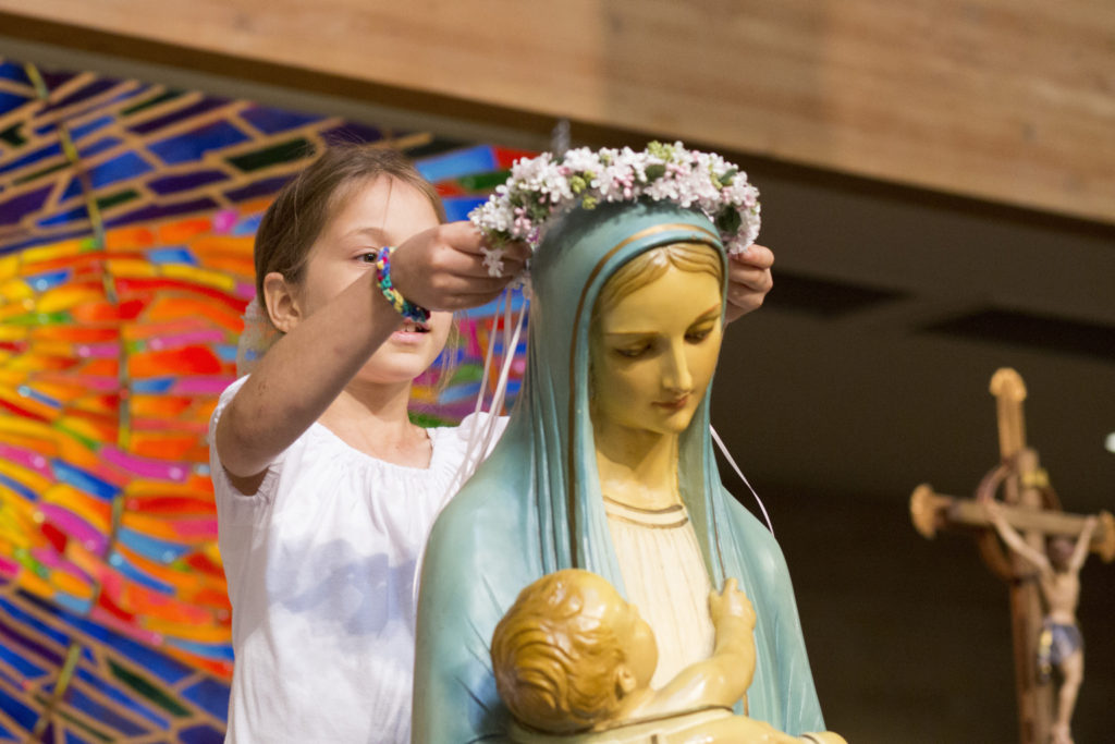 Evita Ravet, 8, places a crown of flowers onto the head of a statue of Mary during a May Crowning ceremony at St. Catherine of Siena Church in Austin, Texas, May 3. (CNS photo/Tom McCarthy Jr.)