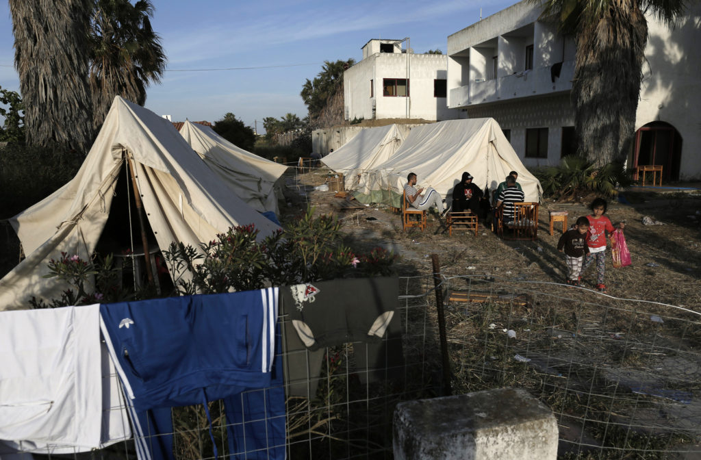 Syrian refugees sit outside their tents at the yard of an abandoned hotel on the island of Kos, near the sea border with Turkey and Greece, May 5. (CNS photo/Yannis Kolesdis, EPA) 