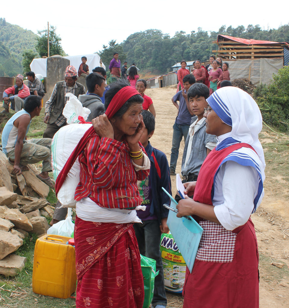 Sister Marica, a member of the Missionaries of Charity, chats with an elderly woman carrying earthquake relief material in the mountains overlooking Kathmandu Valley May 16 in Nepal. (CNS photo/Anto Akkara) 