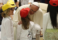 Pope Francis greets children as they present a helmet during an audience with children from the Fabbrica della Pace group in Paul VI hall at the Vatican May 11. The initiative seeks to promote peace, tolerance and inclusion in Italian elementary schools. (CNS photo/Paul Haring) 